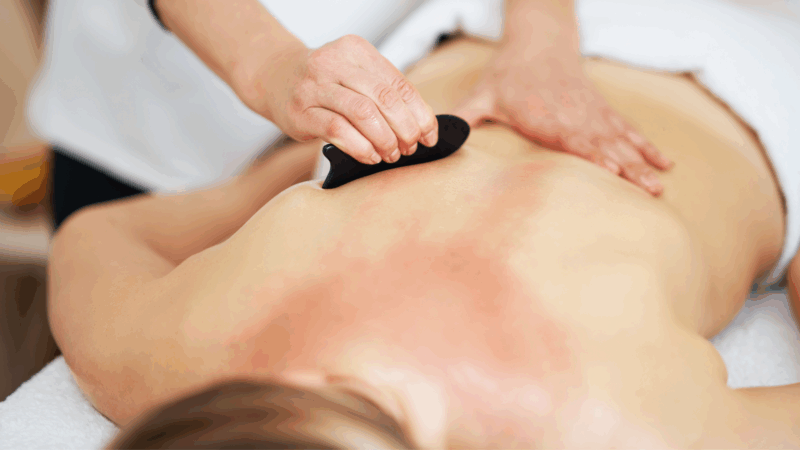 A woman receiving a Gua Sha massage services